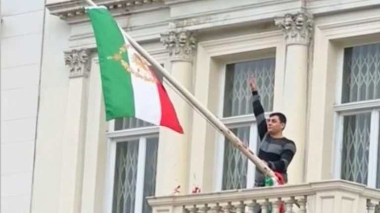 Protester scales Iranian Embassy in London, tears down regime flag, hoists pre-revolution symbol